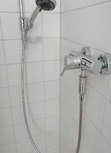 Ein moderner Duschkopf und Wasserhahn in einem Badezimmer, hochwertige Sanitärarmaturen für Duschen und Badrenovierung.