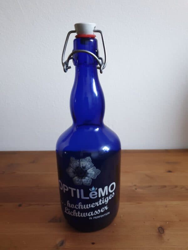 Elegante blaue Glasflasche mit Korkverschluss und Metallverschluss, ideal für stilvolles Trinken.