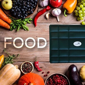 Präzise digitale Waage für Lebensmittel mit Schumann 7.83® Technologie, ideal für gesunde Ernährung und Kochen, auf einem Holztisch mit frischem Obst und Gemüse.