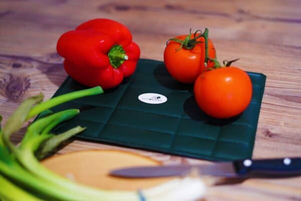 Frische rote Paprika und Tomaten auf einem Schneidebrett, bereit zum Kochen, im Zusammenhang mit Schumann 7.83® Food Produkten.